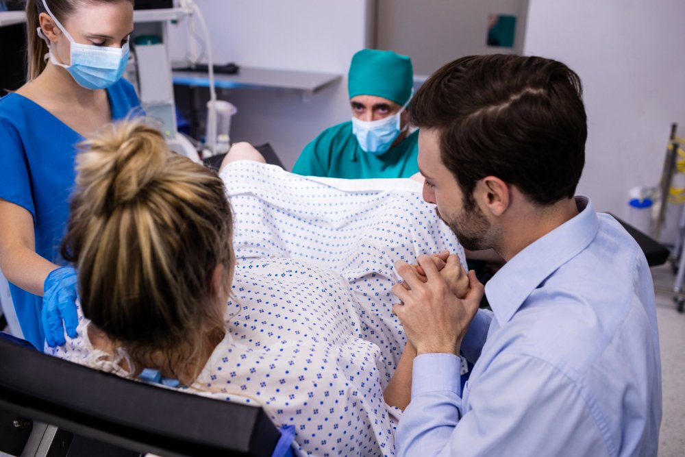 Pregnant woman in labor supported by partner and medical team during delivery