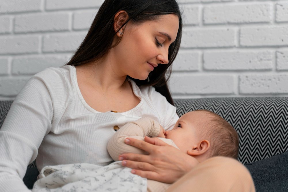 Mother breastfeeding newborn during postpartum care at home